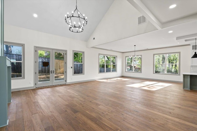 unfurnished living room featuring wood finished floors, a chandelier, french doors, visible vents, and recessed lighting