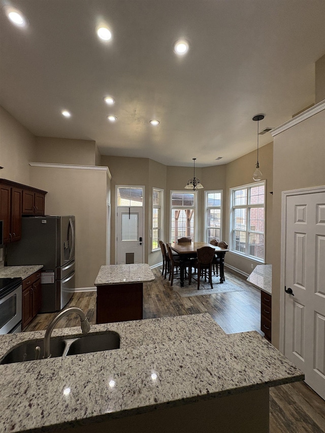 kitchen featuring a sink, a kitchen island, stainless steel appliances, and dark wood finished floors