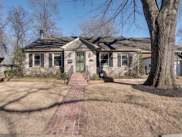 ranch-style house featuring brick siding and a chimney
