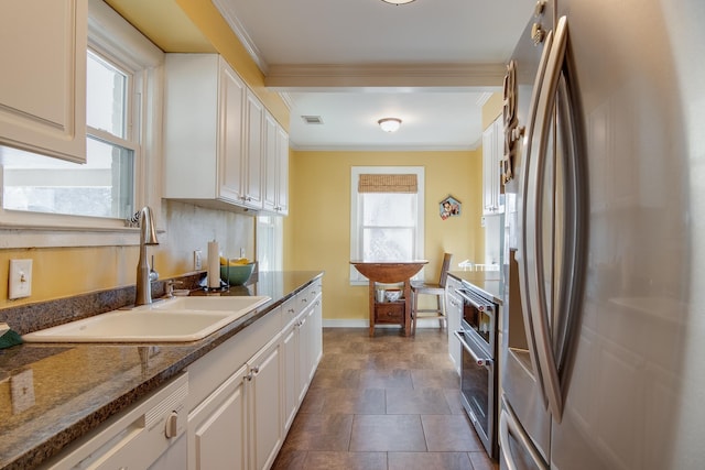 kitchen with stainless steel refrigerator with ice dispenser, a sink, white cabinets, crown molding, and dishwasher