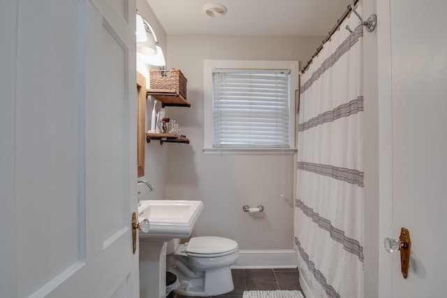 bathroom with tile patterned flooring, curtained shower, toilet, and baseboards