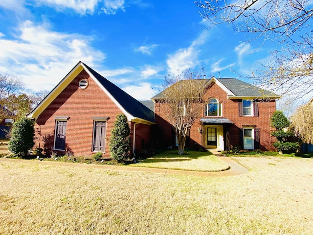 view of front of home featuring brick siding and a front yard