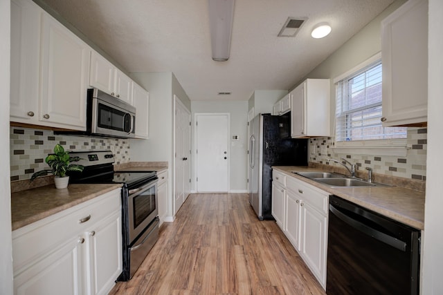 12065 Hidden Trl, Arlington, TN 38002 - kitchen featuring visible vents, light wood-style flooring, a sink, white cabinetry, and stainless steel appliances