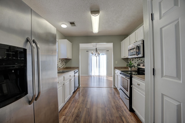 12065 Hidden Trl, Arlington, TN 38002 - kitchen with dark wood finished floors, white cabinets, and appliances with stainless steel finishes