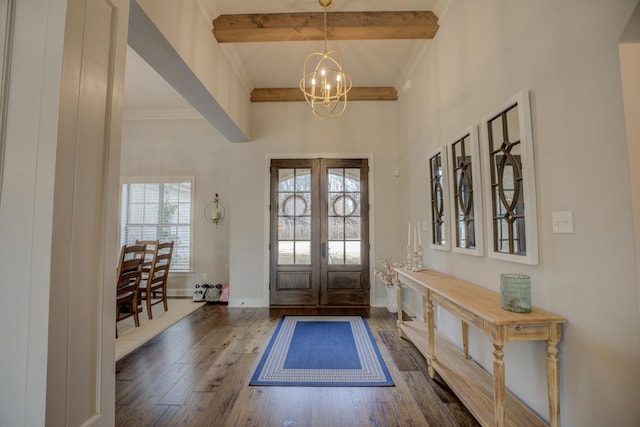 entryway with hardwood / wood-style floors, an inviting chandelier, beamed ceiling, and crown molding