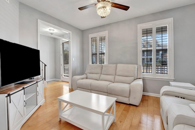 living room featuring plenty of natural light, a ceiling fan, and light wood finished floors