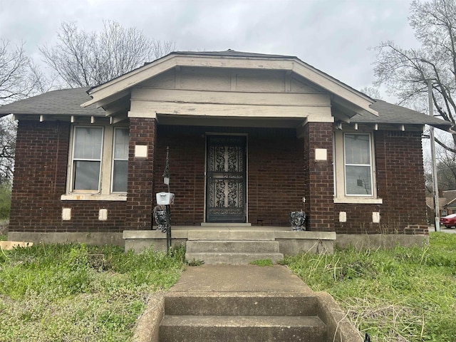 view of front of home with covered porch and brick siding