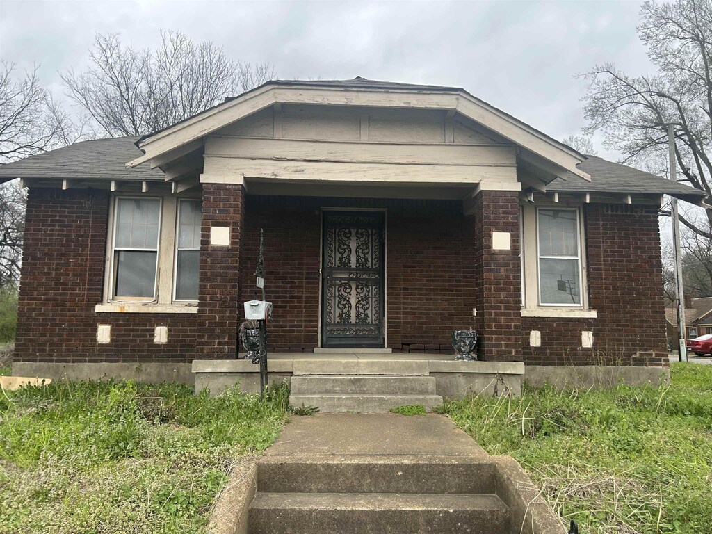 view of front of house featuring brick siding and a porch