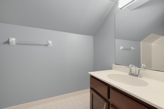 7570 Chapel Ridge Dr, Memphis, TN 38016 - bathroom featuring tile patterned floors, baseboards, vanity, and vaulted ceiling