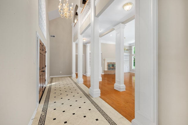 7570 Chapel Ridge Dr, Memphis, TN 38016 - foyer entrance with visible vents, baseboards, a high ceiling, decorative columns, and a glass covered fireplace