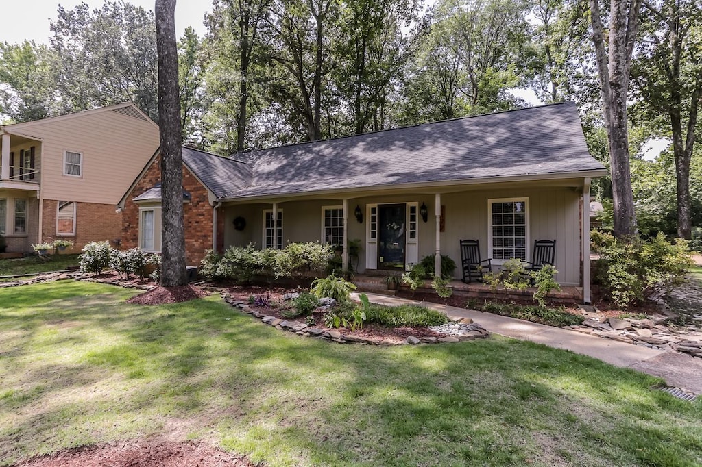 view of front of home with a porch and a front lawn