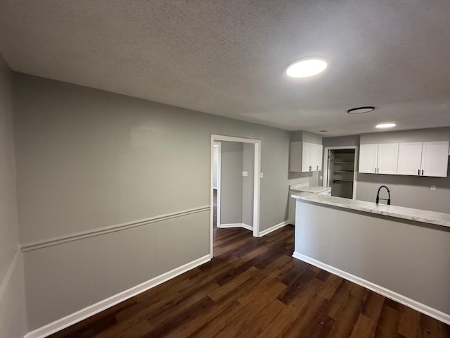 3617 Millington Rd, Memphis, TN 38127 - kitchen featuring a sink, a textured ceiling, dark wood finished floors, white cabinetry, and baseboards