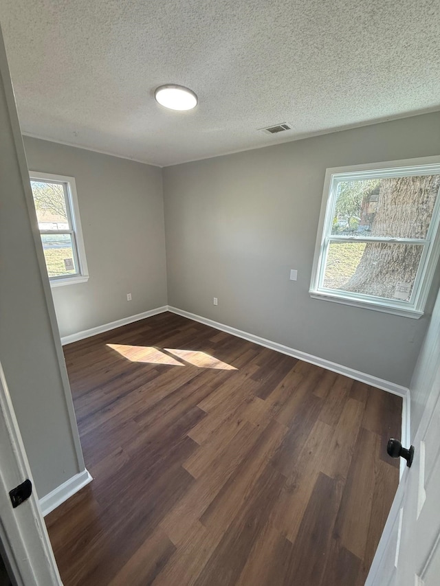 3617 Millington Rd, Memphis, TN 38127 - spare room with baseboards, visible vents, dark wood-style flooring, and a textured ceiling