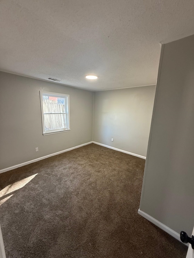 3617 Millington Rd, Memphis, TN 38127 - spare room featuring visible vents, a textured ceiling, baseboards, and dark colored carpet