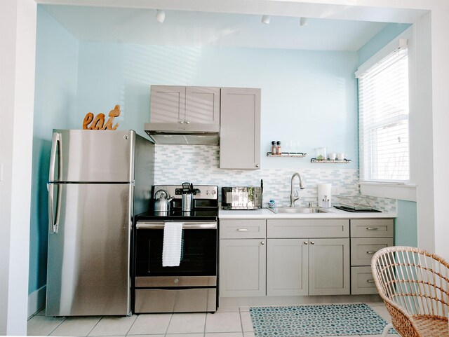 kitchen featuring a sink, tasteful backsplash, appliances with stainless steel finishes, and under cabinet range hood