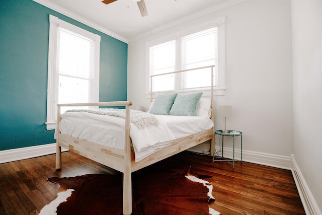bedroom featuring multiple windows, wood finished floors, and ornamental molding