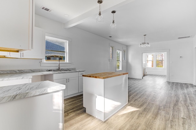 1131 Rozelle St, Memphis, TN 38106 - kitchen with butcher block countertops, visible vents, decorative light fixtures, and light wood-style floors