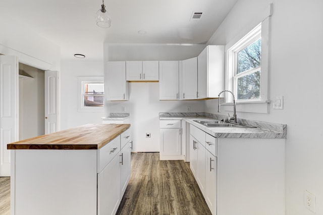 1131 Rozelle St, Memphis, TN 38106 - kitchen featuring white cabinetry, butcher block countertops, dark wood-style flooring, a sink, and visible vents