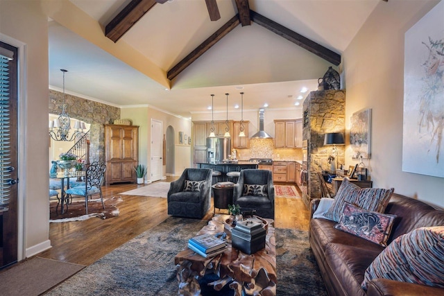 living room with high vaulted ceiling, arched walkways, an inviting chandelier, light wood-style flooring, and beam ceiling