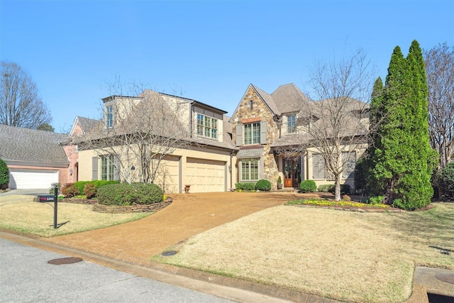 view of front of house featuring an attached garage, a front lawn, driveway, and stucco siding