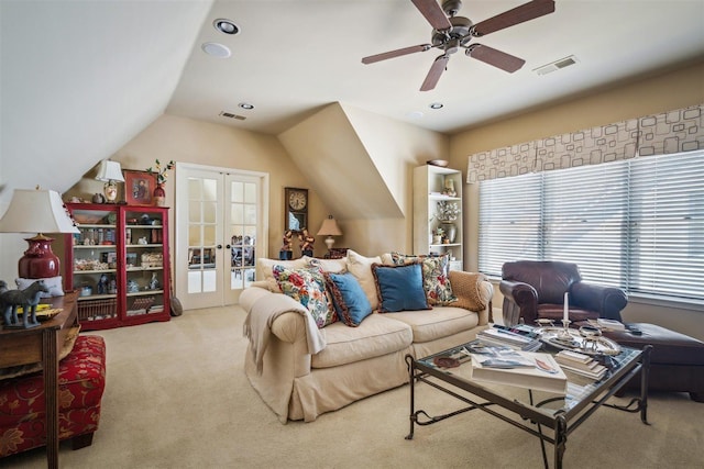 carpeted living room featuring ceiling fan, lofted ceiling, french doors, and visible vents
