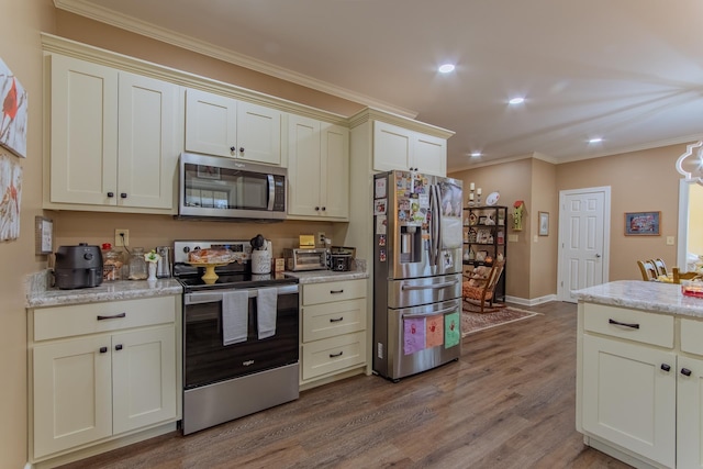 kitchen with wood finished floors, appliances with stainless steel finishes, baseboards, ornamental molding, and recessed lighting