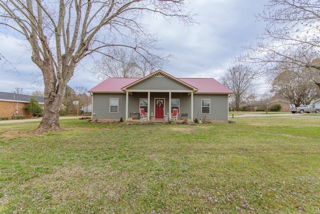 bungalow-style house with metal roof, a front yard, a porch, and concrete driveway