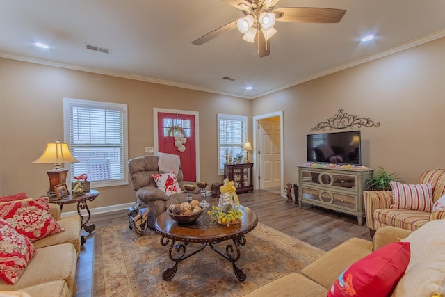living room featuring wood finished floors, a healthy amount of sunlight, ceiling fan, and visible vents