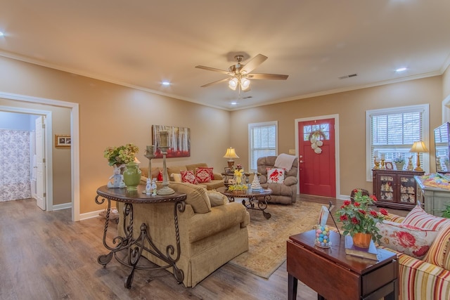 living room featuring wood finished floors, plenty of natural light, ceiling fan, and visible vents
