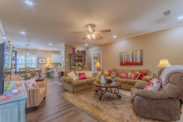 living room featuring recessed lighting, ornamental molding, ceiling fan, visible vents, and wood finished floors