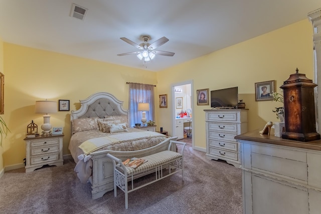 carpeted bedroom with connected bathroom, baseboards, visible vents, and ceiling fan