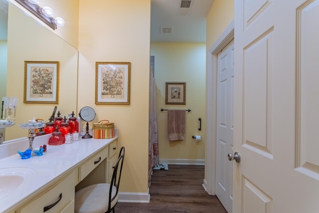 bathroom with baseboards, visible vents, wood finished floors, and vanity