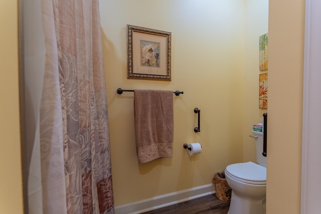 bathroom featuring toilet, baseboards, and wood finished floors