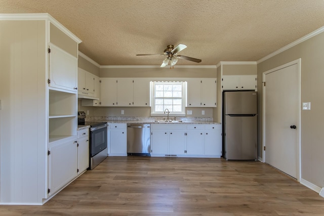 kitchen featuring a sink, a ceiling fan, appliances with stainless steel finishes, light wood-type flooring, and white cabinets