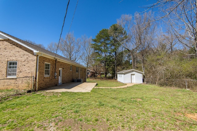 view of yard featuring an outbuilding, a shed, fence, and a patio area