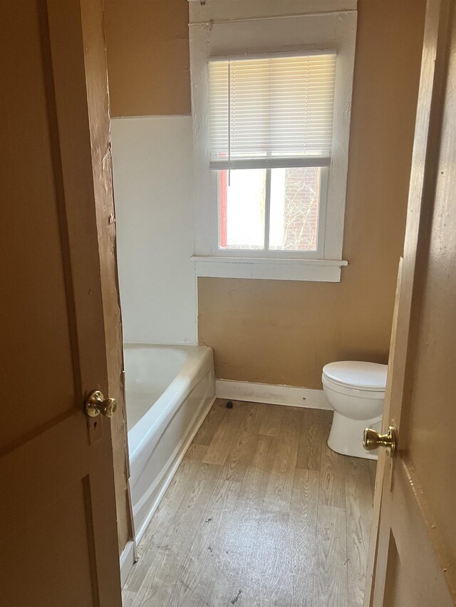 1535 Southern Ave, Memphis, TN 38114 - full bathroom featuring wood finished floors, toilet, a tub, and baseboards