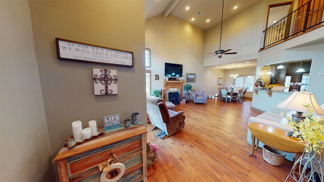 100 Carefree Ln, Counce, TN 38326 - living room featuring light wood-style floors, beam ceiling, a fireplace, a ceiling fan, and high vaulted ceiling