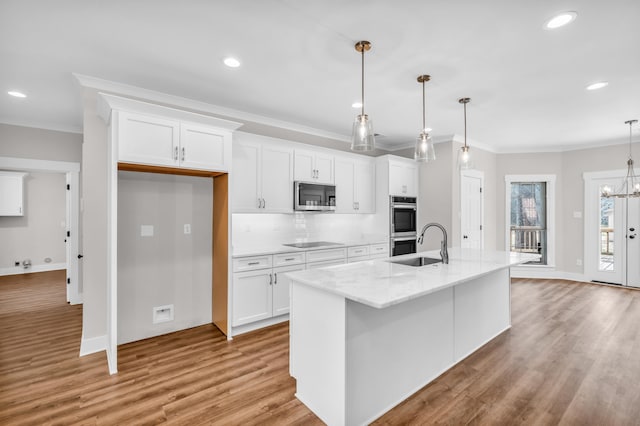 kitchen with white cabinetry, ornamental molding, and stainless steel appliances