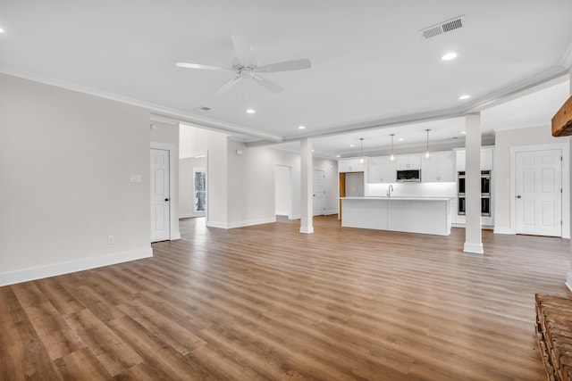 unfurnished living room with light wood finished floors, visible vents, crown molding, and a ceiling fan