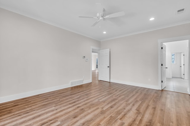 empty room featuring visible vents, crown molding, ceiling fan, and light wood-type flooring