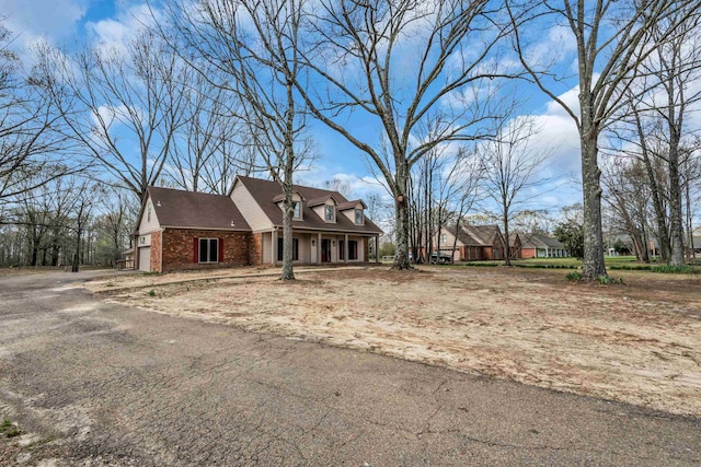 view of front of home with driveway, an attached garage, and brick siding