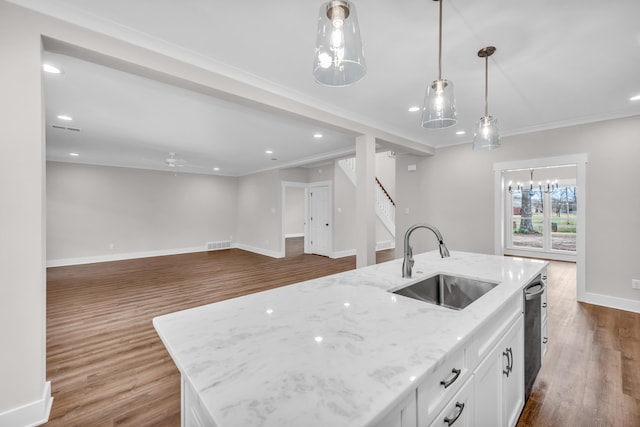 kitchen featuring a sink, wood finished floors, dishwasher, baseboards, and white cabinets