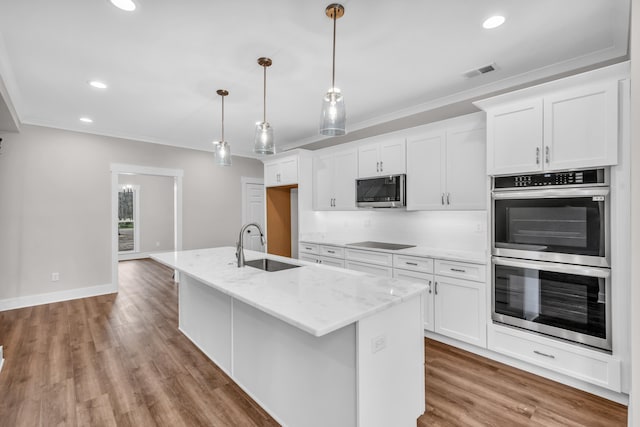 kitchen with white cabinets, visible vents, ornamental molding, wood finished floors, and appliances with stainless steel finishes
