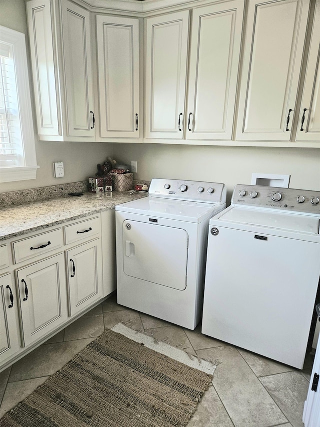 clothes washing area featuring cabinet space and separate washer and dryer