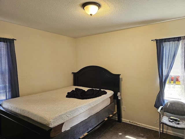 3240 Mario St, Memphis, TN 38127 - bedroom featuring baseboards, dark colored carpet, and a textured ceiling