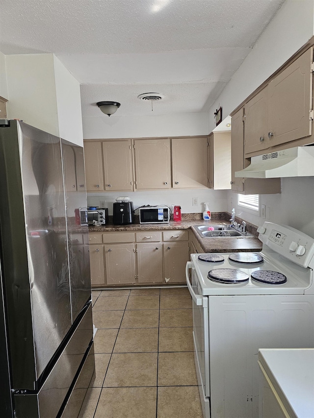 3240 Mario St, Memphis, TN 38127 - kitchen featuring a sink, freestanding refrigerator, white electric range, under cabinet range hood, and light tile patterned floors