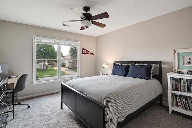 bedroom with carpet floors, a ceiling fan, a textured ceiling, baseboards, and visible vents