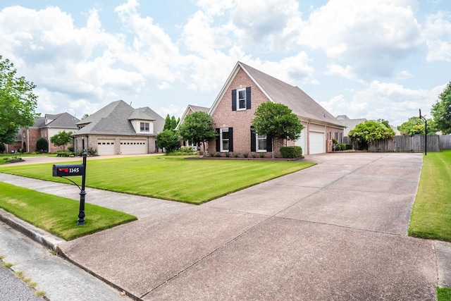view of front of home featuring a front yard, concrete driveway, fence, an attached garage, and brick siding