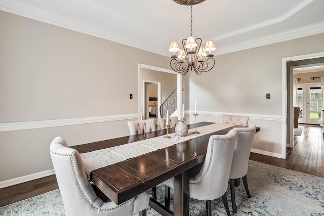 dining area featuring baseboards, wood finished floors, stairway, and a chandelier