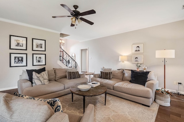 living area with crown molding, baseboards, stairs, ceiling fan with notable chandelier, and dark wood-style floors